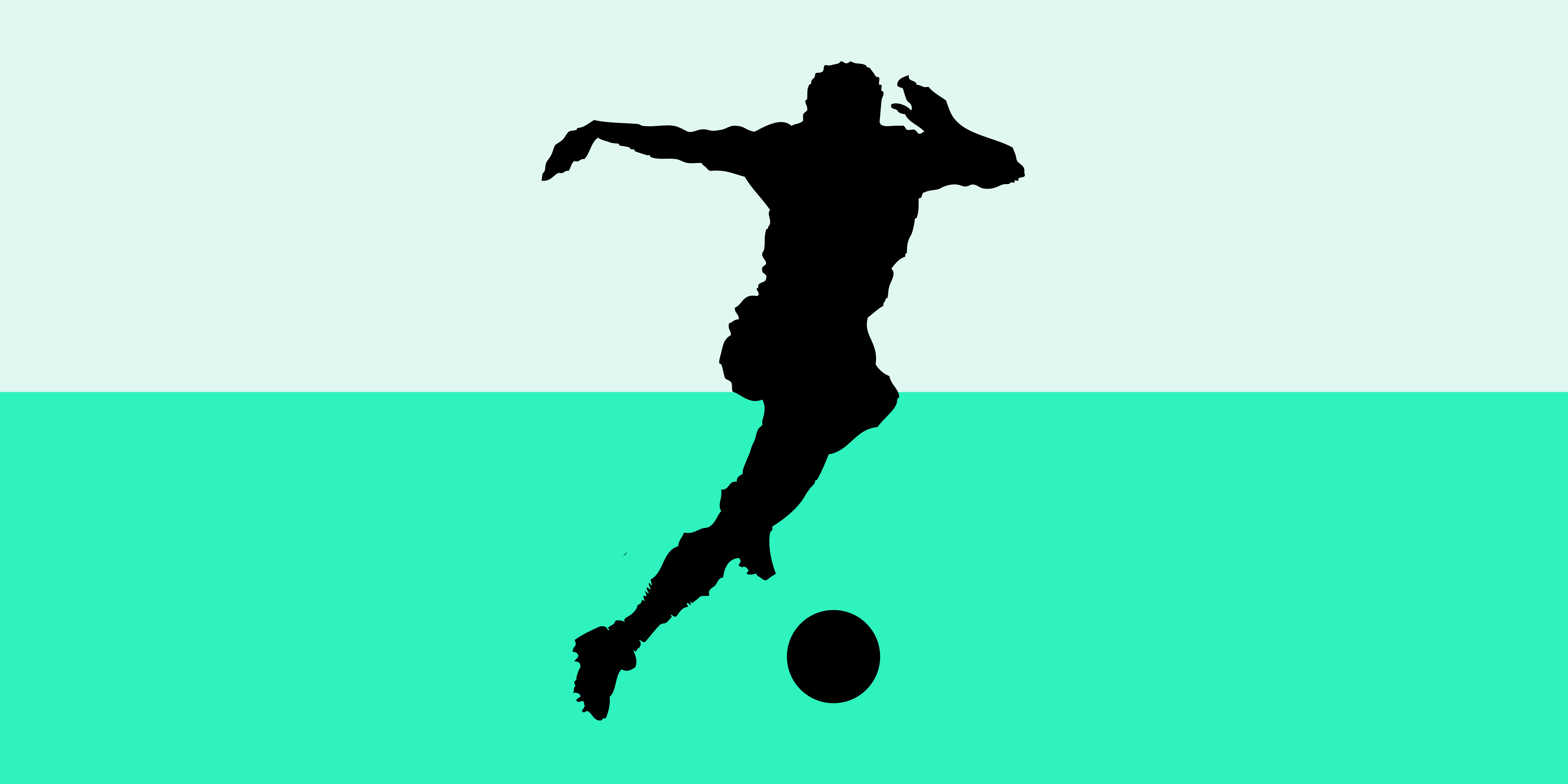 Silhouette of football player kicking ball